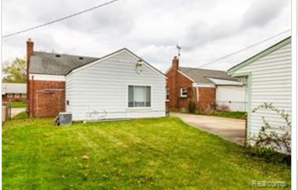 rear view of property featuring a lawn