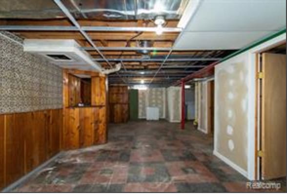 basement featuring wood walls