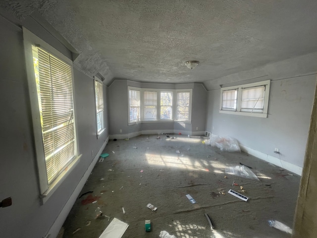 empty room with a textured ceiling and vaulted ceiling