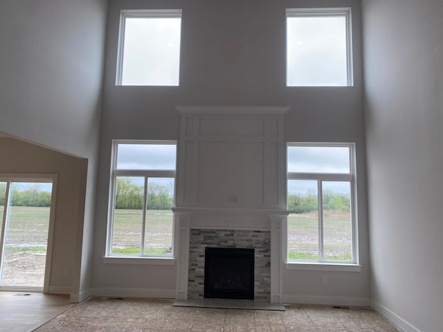 32627 Adam Brown Dr, Rockwood, MI 48173 - unfurnished living room featuring a high ceiling, baseboards, and a fireplace with raised hearth