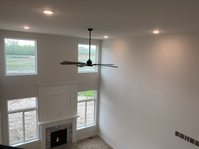 detailed view of baseboards, recessed lighting, a ceiling fan, and a fireplace