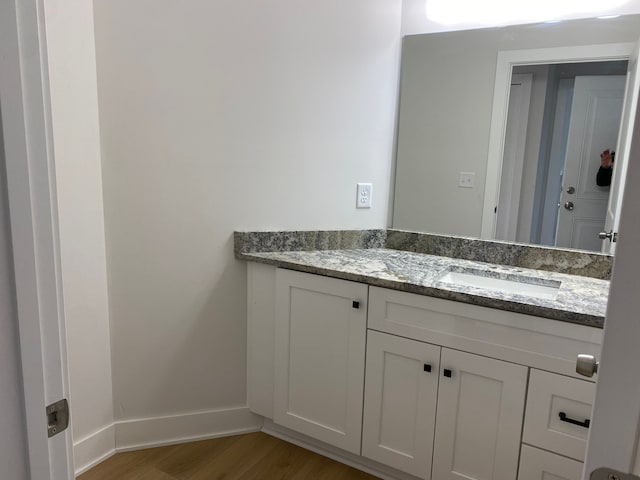 bathroom featuring wood finished floors, vanity, and baseboards