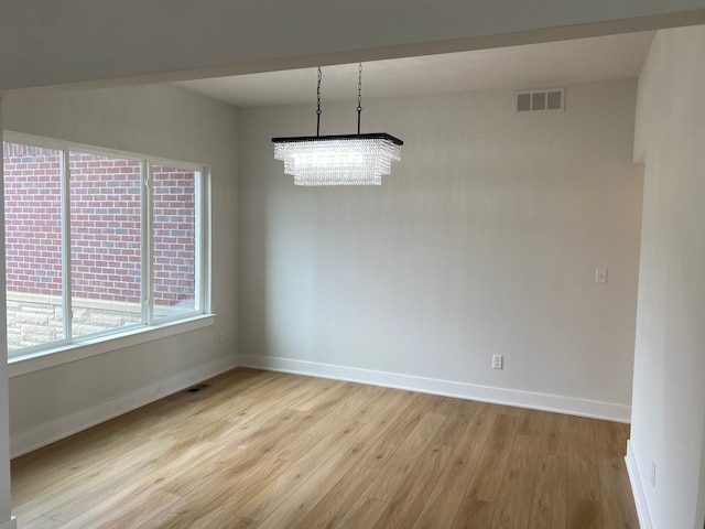 32627 Adam Brown Dr, Rockwood, MI 48173 - empty room with light wood-style floors, baseboards, and a chandelier