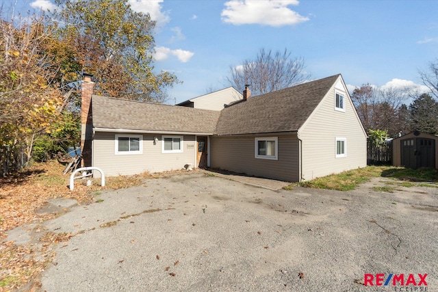 rear view of property featuring a shed