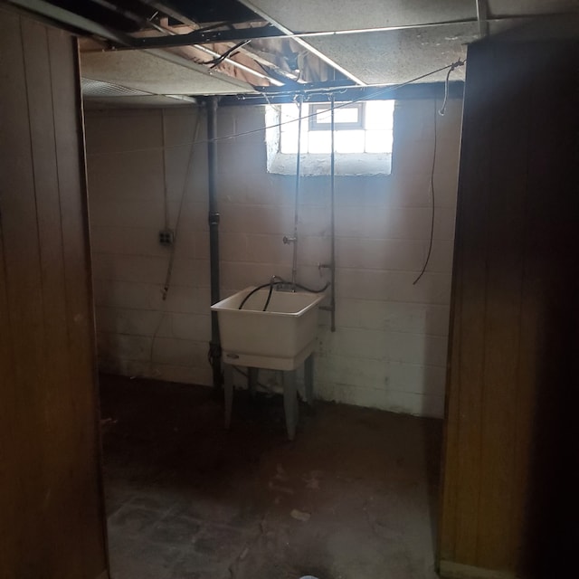 basement featuring a sink and concrete block wall