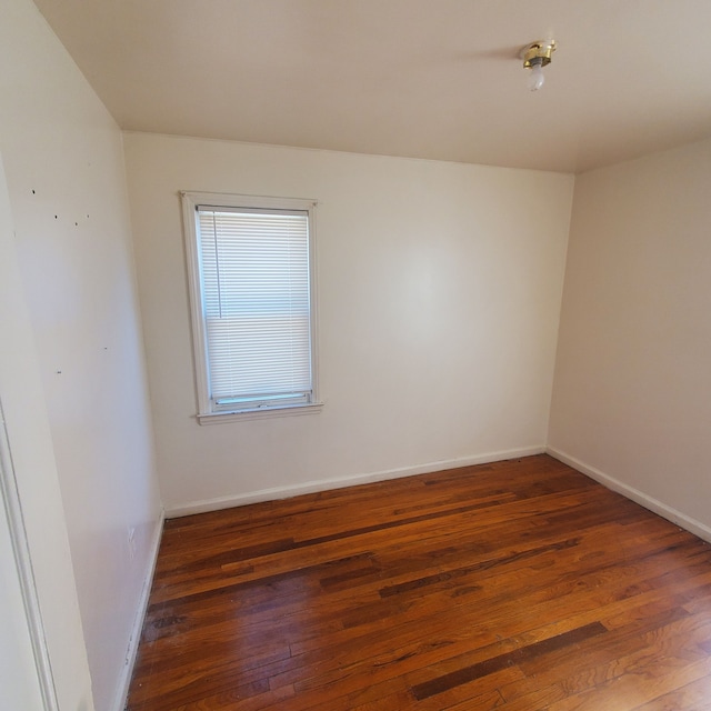 spare room featuring hardwood / wood-style floors and baseboards