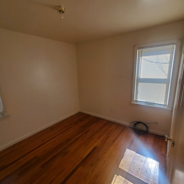 empty room featuring baseboards and wood finished floors