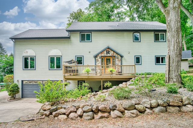 back of property with a garage and a wooden deck