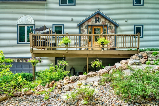 back of property featuring a garage and a deck