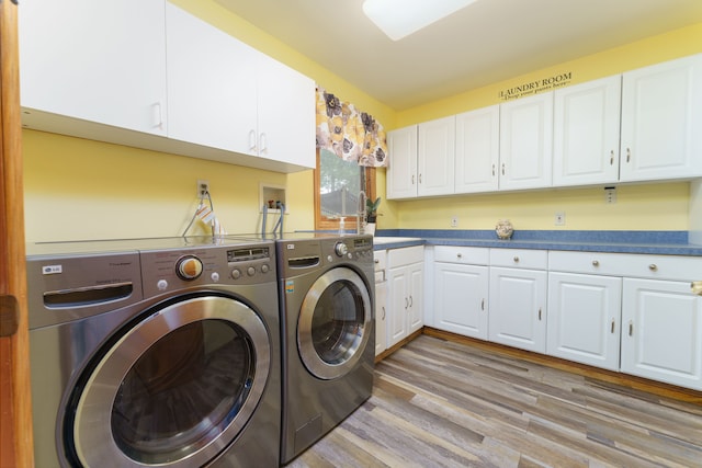 laundry area with cabinets, light wood-type flooring, and separate washer and dryer