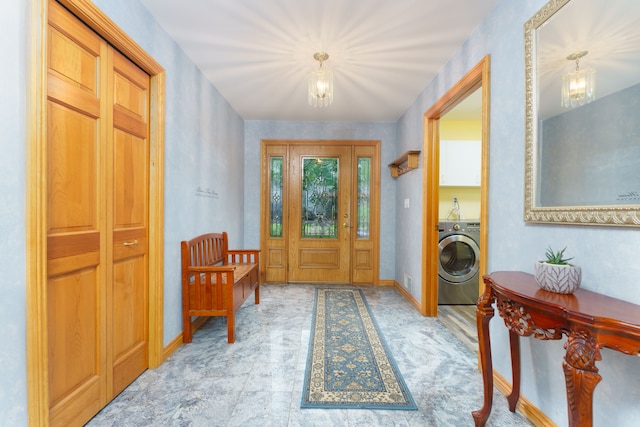 foyer entrance featuring a chandelier and washer / clothes dryer