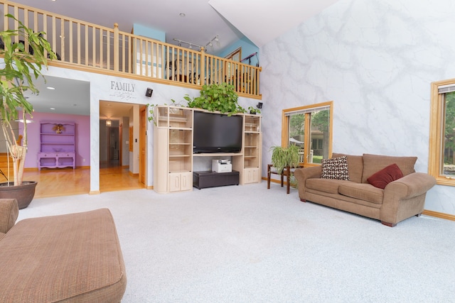 living room featuring carpet and high vaulted ceiling