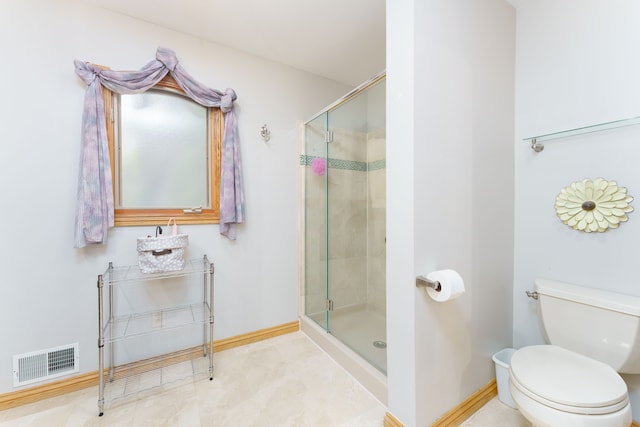 bathroom featuring tile patterned flooring, toilet, and a shower with door