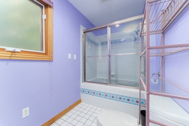 bathroom featuring tile patterned floors, toilet, and enclosed tub / shower combo