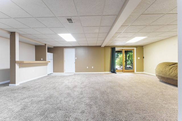 basement with carpet flooring, a drop ceiling, and white refrigerator