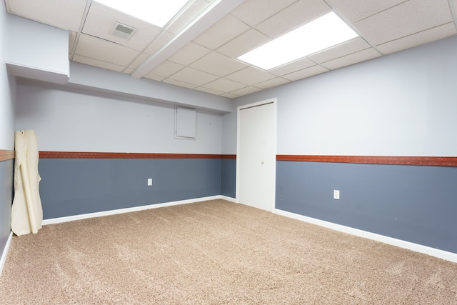 empty room featuring carpet and a drop ceiling