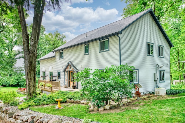 rear view of house with a lawn and a wooden deck