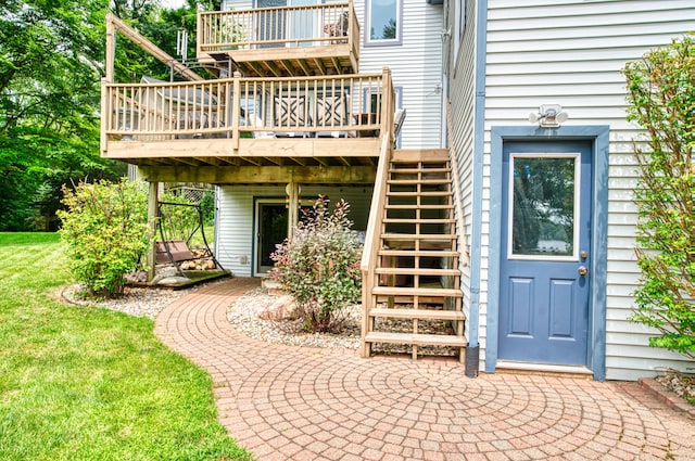 entrance to property featuring a deck and a lawn