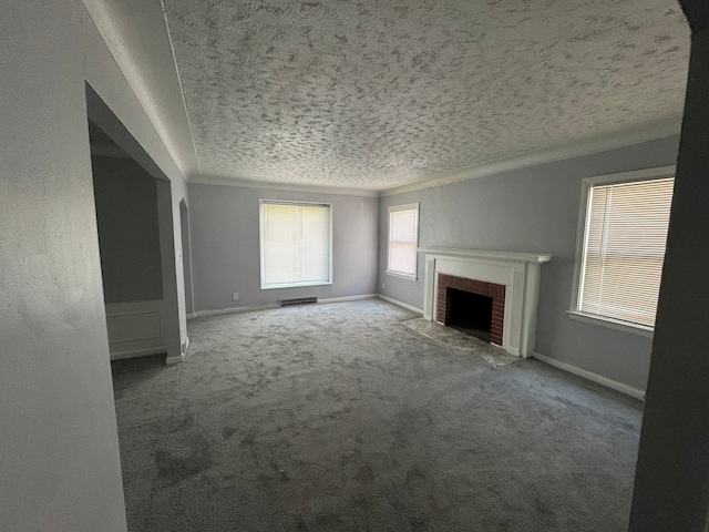 unfurnished living room with a textured ceiling, carpet floors, and a brick fireplace