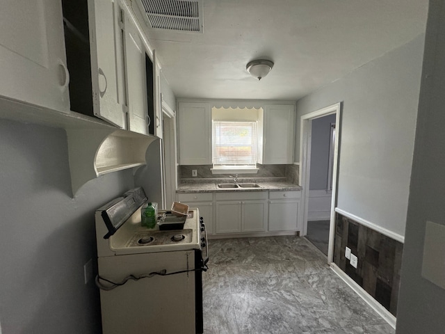 kitchen with white range with electric stovetop, sink, and white cabinets