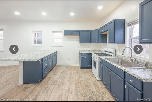 kitchen featuring blue cabinetry, light wood-type flooring, gas range gas stove, and sink