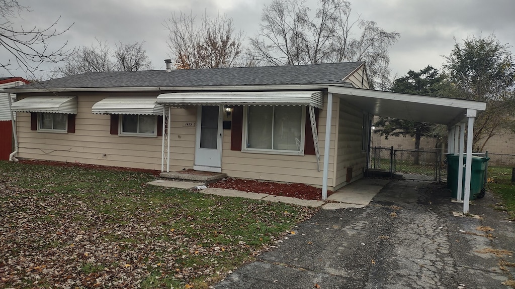 view of front facade with a front yard and a carport