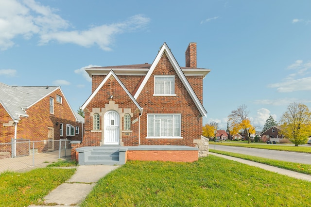 tudor-style house featuring a front lawn