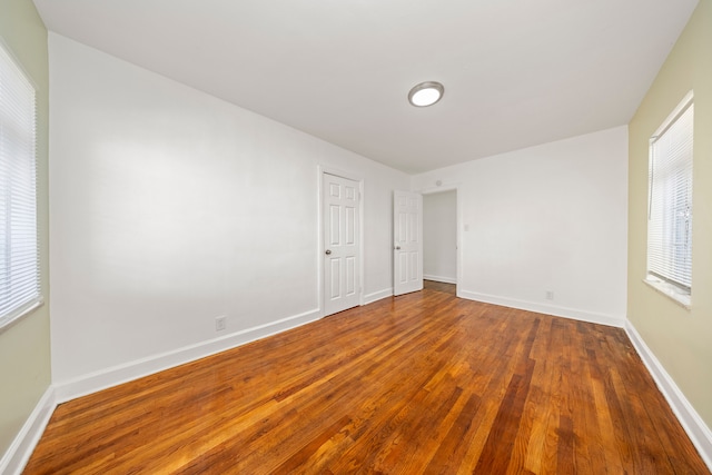 unfurnished room with wood-type flooring and a wealth of natural light