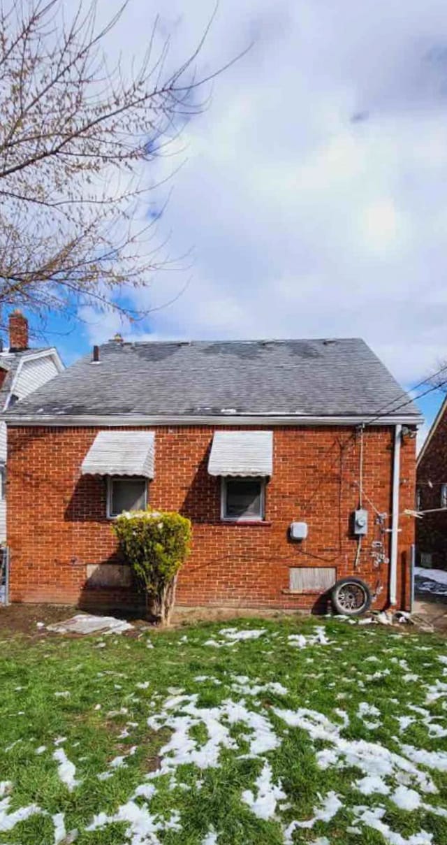 rear view of house featuring a yard