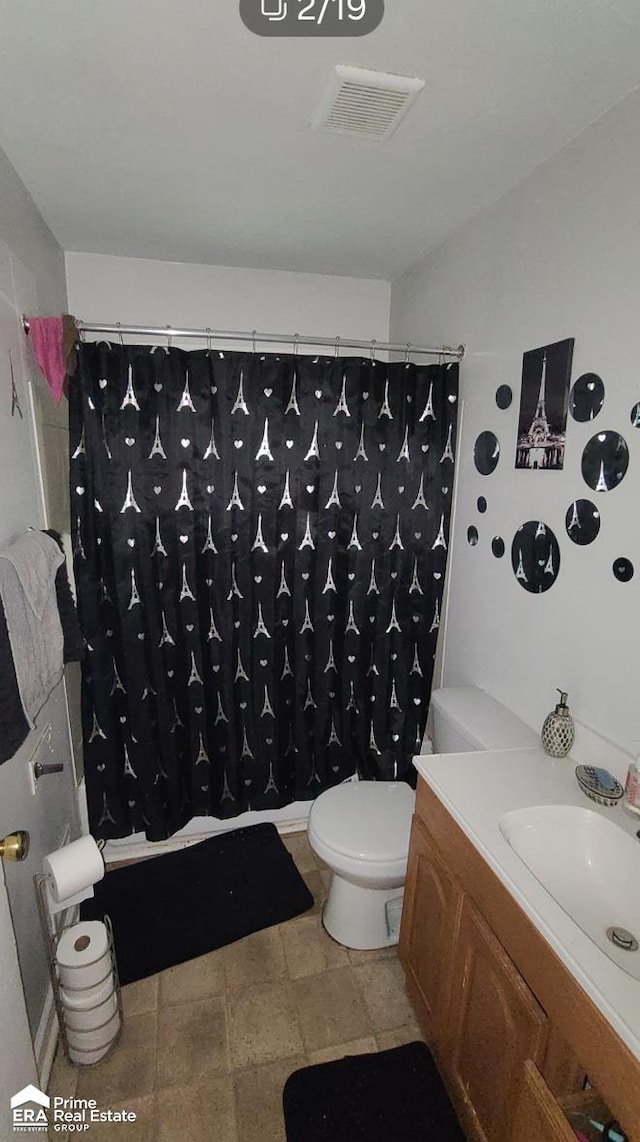 full bathroom with vanity, shower / tub combo, and toilet