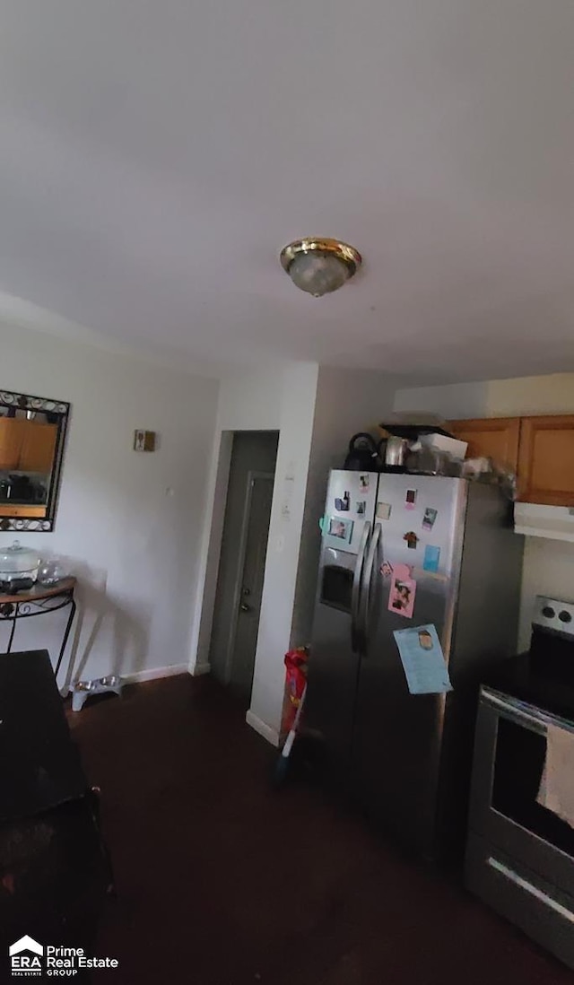 kitchen featuring stainless steel fridge with ice dispenser, electric range, and extractor fan