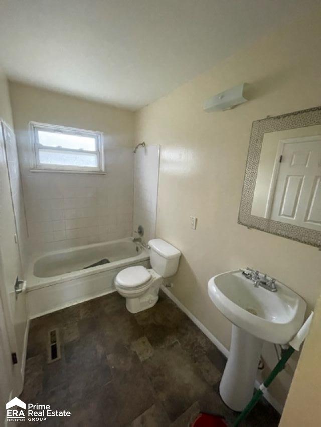 full bathroom with sink, tiled shower / bath combo, and toilet