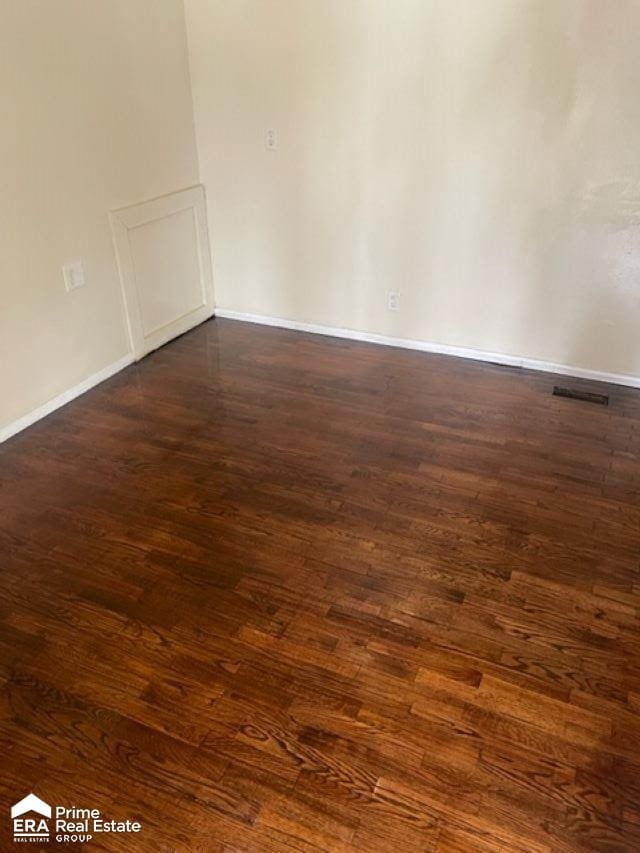 unfurnished room with dark hardwood / wood-style flooring