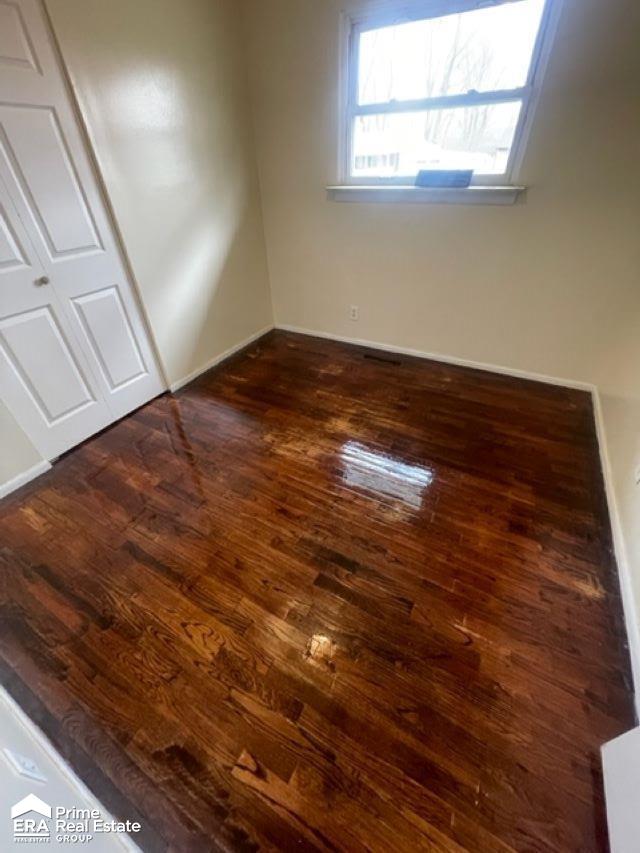 unfurnished bedroom with dark hardwood / wood-style floors