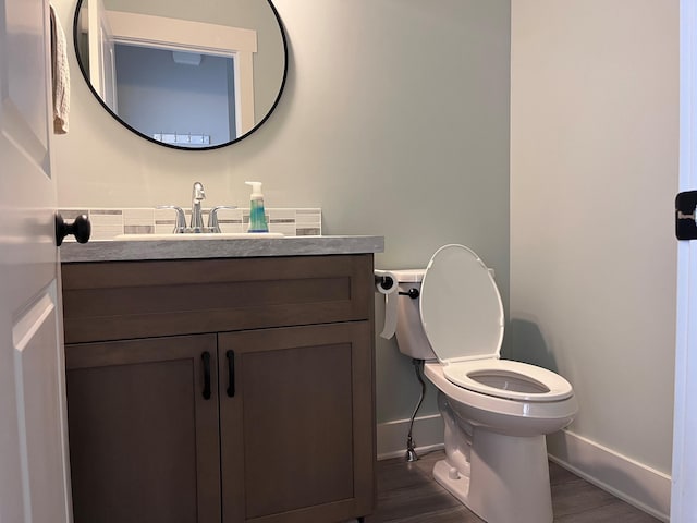 bathroom with hardwood / wood-style flooring, vanity, and toilet