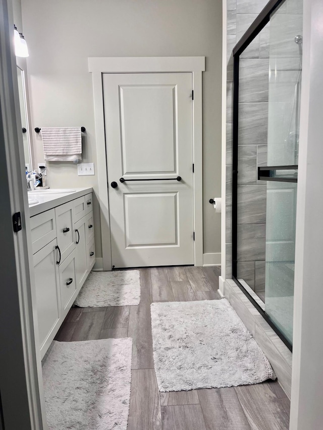 bathroom featuring a shower with door, vanity, and hardwood / wood-style floors