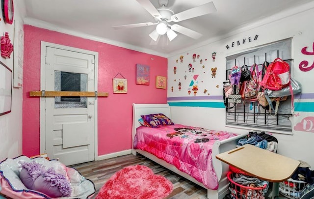 bedroom with wood-type flooring, ceiling fan, and crown molding