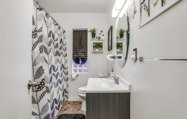 bathroom with vanity, toilet, and walk in shower