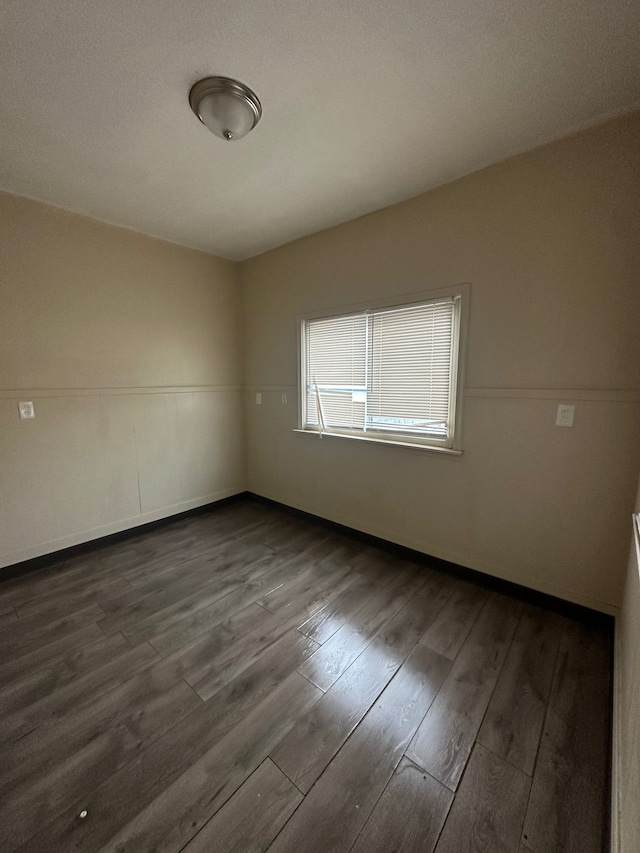 spare room with dark hardwood / wood-style flooring