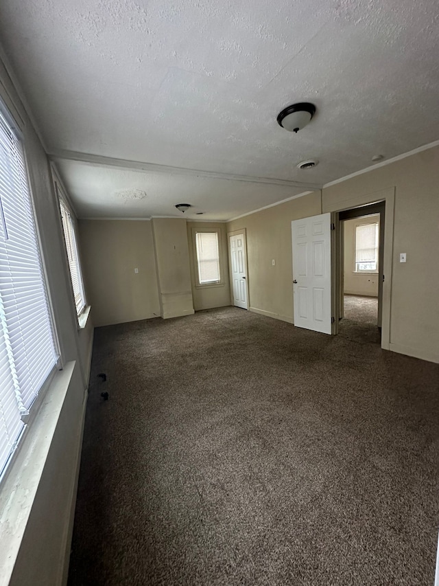 carpeted empty room featuring a textured ceiling