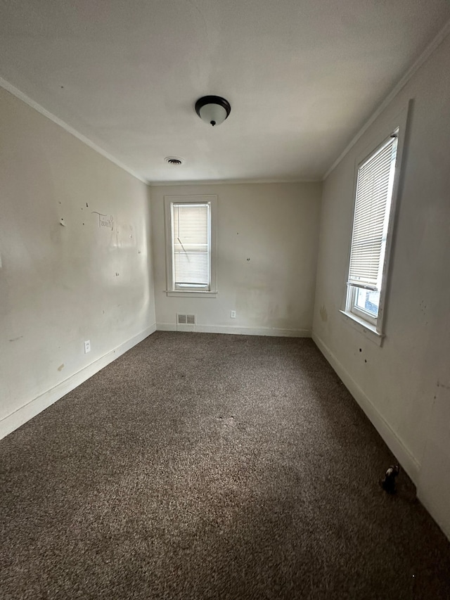 carpeted spare room featuring crown molding