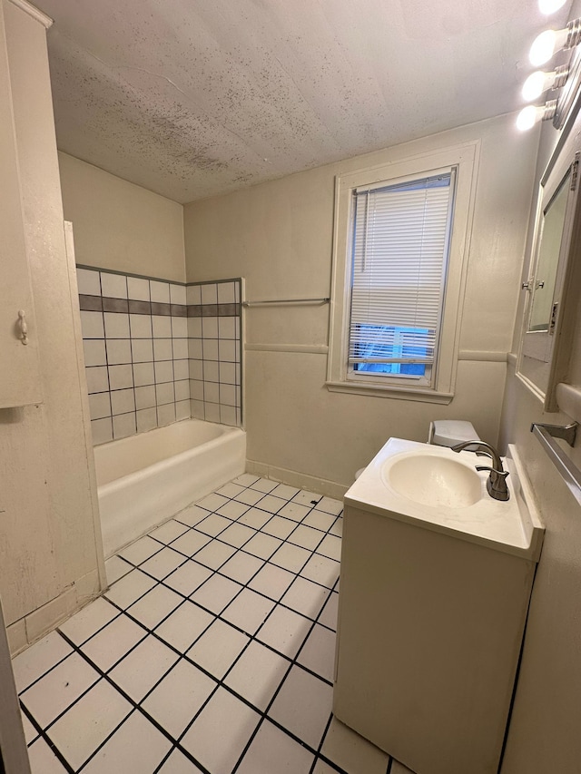 bathroom featuring a textured ceiling, tile patterned flooring, vanity, and a bathing tub