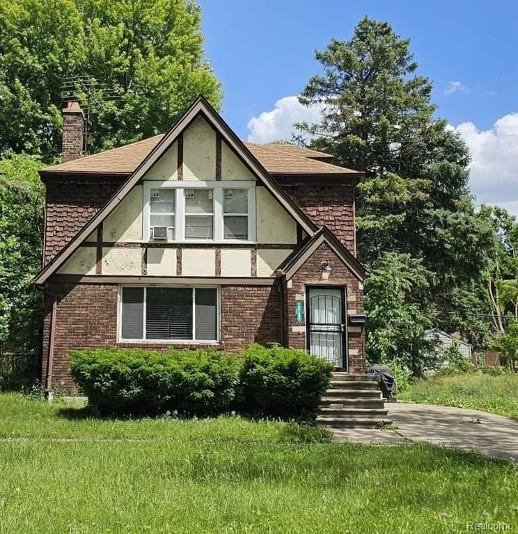 english style home featuring a front lawn