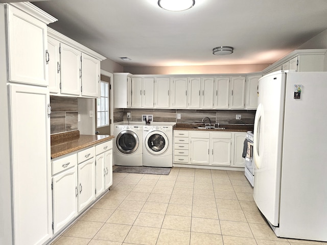 laundry area with light tile patterned floors, washer and clothes dryer, and sink