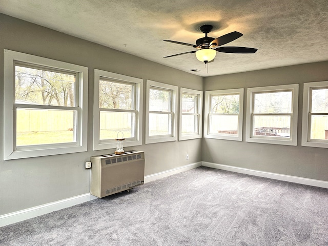 unfurnished sunroom with heating unit and ceiling fan