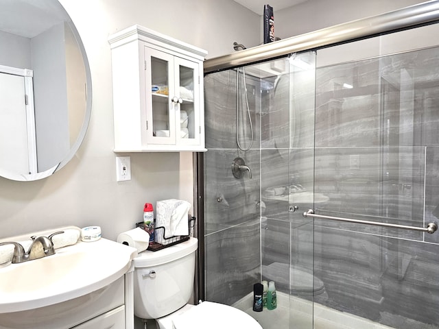 bathroom featuring vanity, toilet, and a shower with door