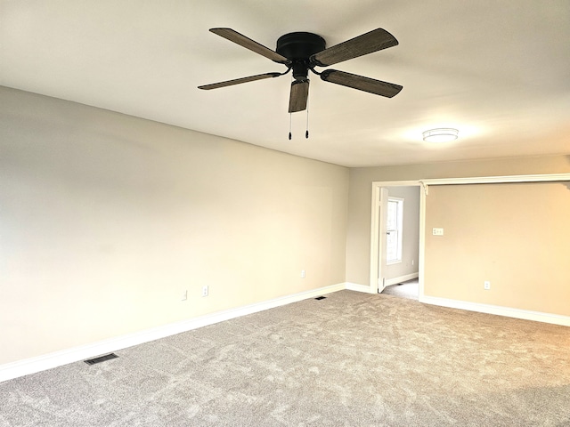 empty room with ceiling fan and carpet floors