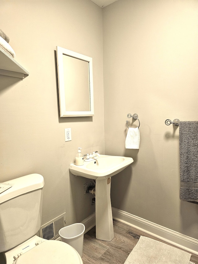 bathroom with hardwood / wood-style floors and toilet