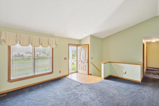 carpeted foyer featuring lofted ceiling