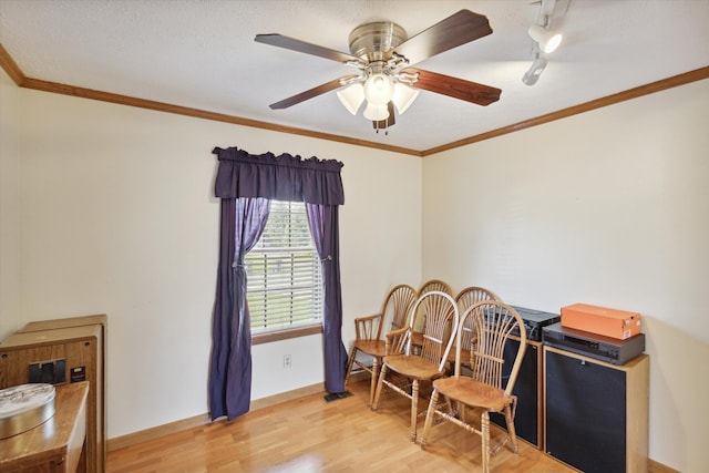 interior space with light wood-type flooring, ceiling fan, and ornamental molding